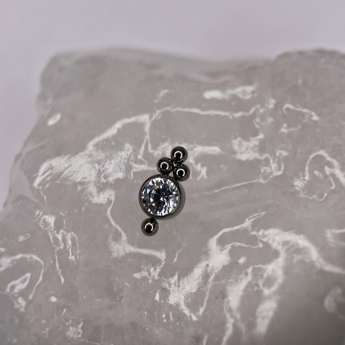 Gioiello in Titanio con zirconi CZ, fiore centrale con opali e sferette